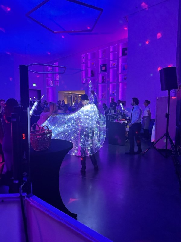 Firmenevent mit LED-Show-Act auf der Tanzfläche in violettem Licht